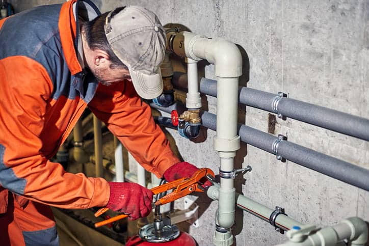 Plumber installing pipework on an Australian commercial site